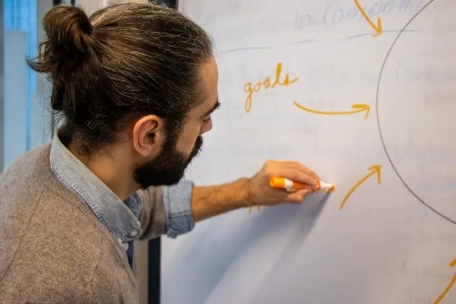 Person writing connected arrows and