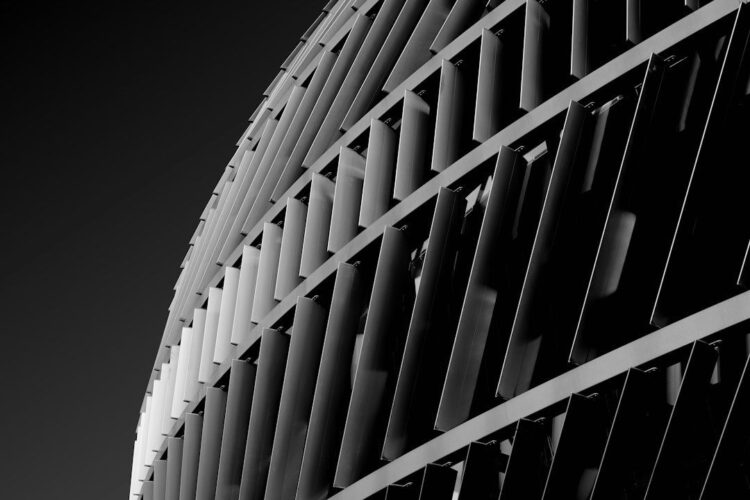 Black-and-white close-up of a building with repeating vertical fins